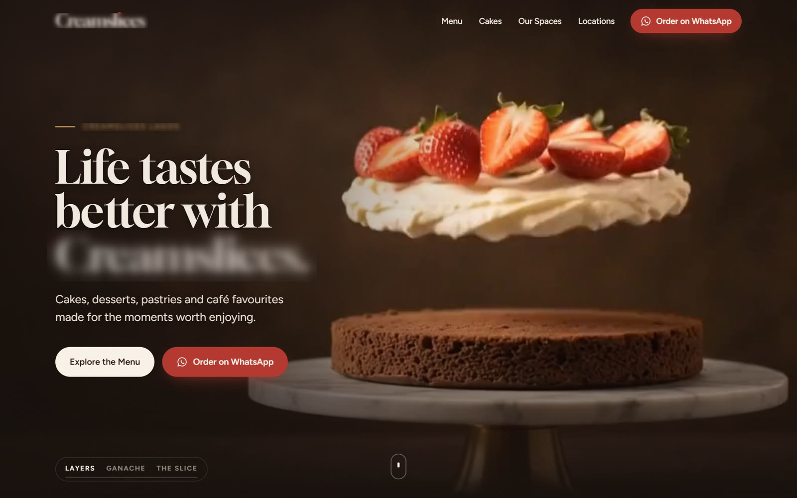 The cake, dessert and café website on a laptop: a layer of cream and strawberries floating above a chocolate sponge on a marble cake stand, with the brand name hidden.